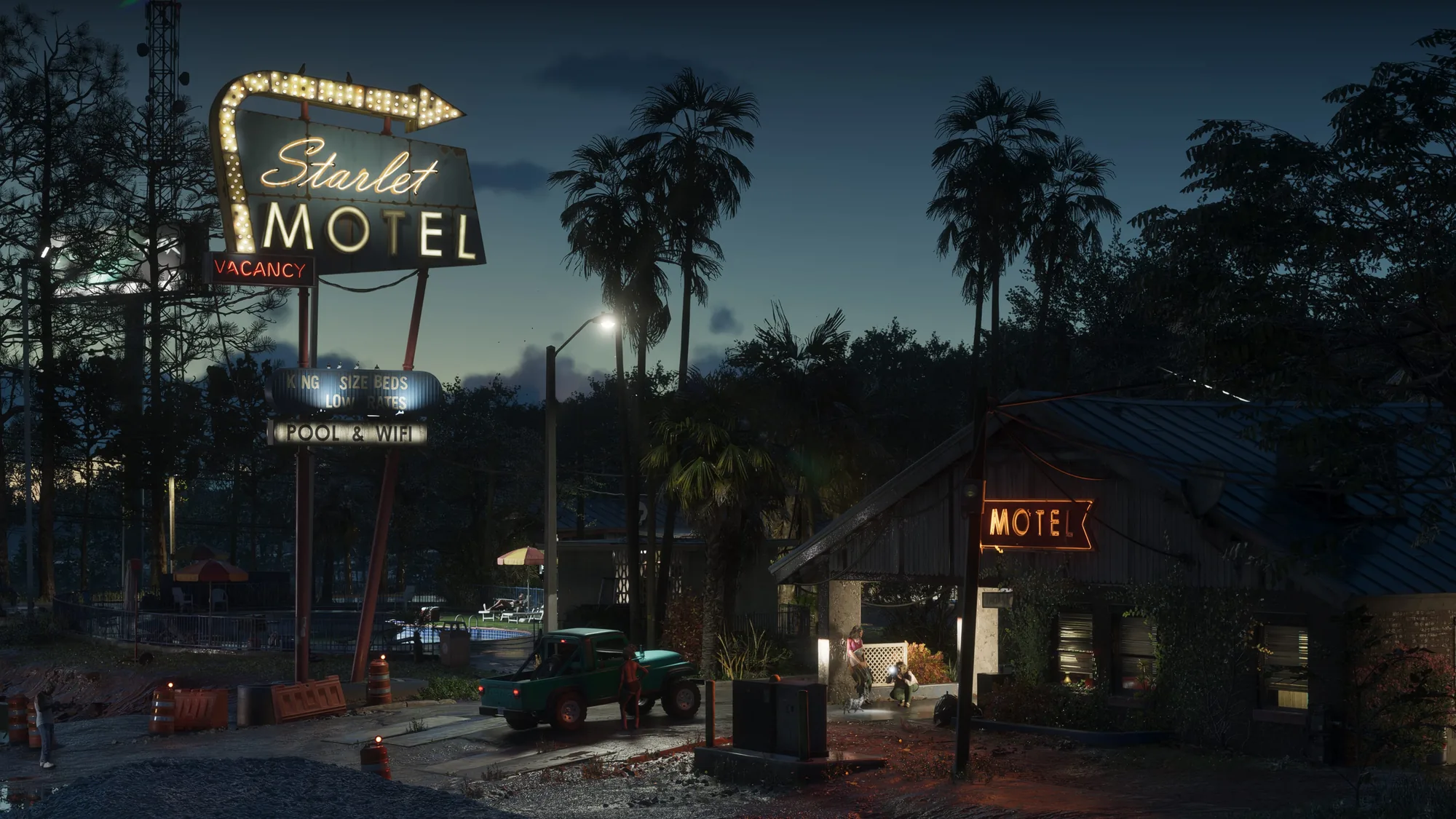 The Starlet Motel at dusk, its vintage red neon vacancy signs lit above weathered buildings, palm trees and a turquoise classic car parked in the lot.